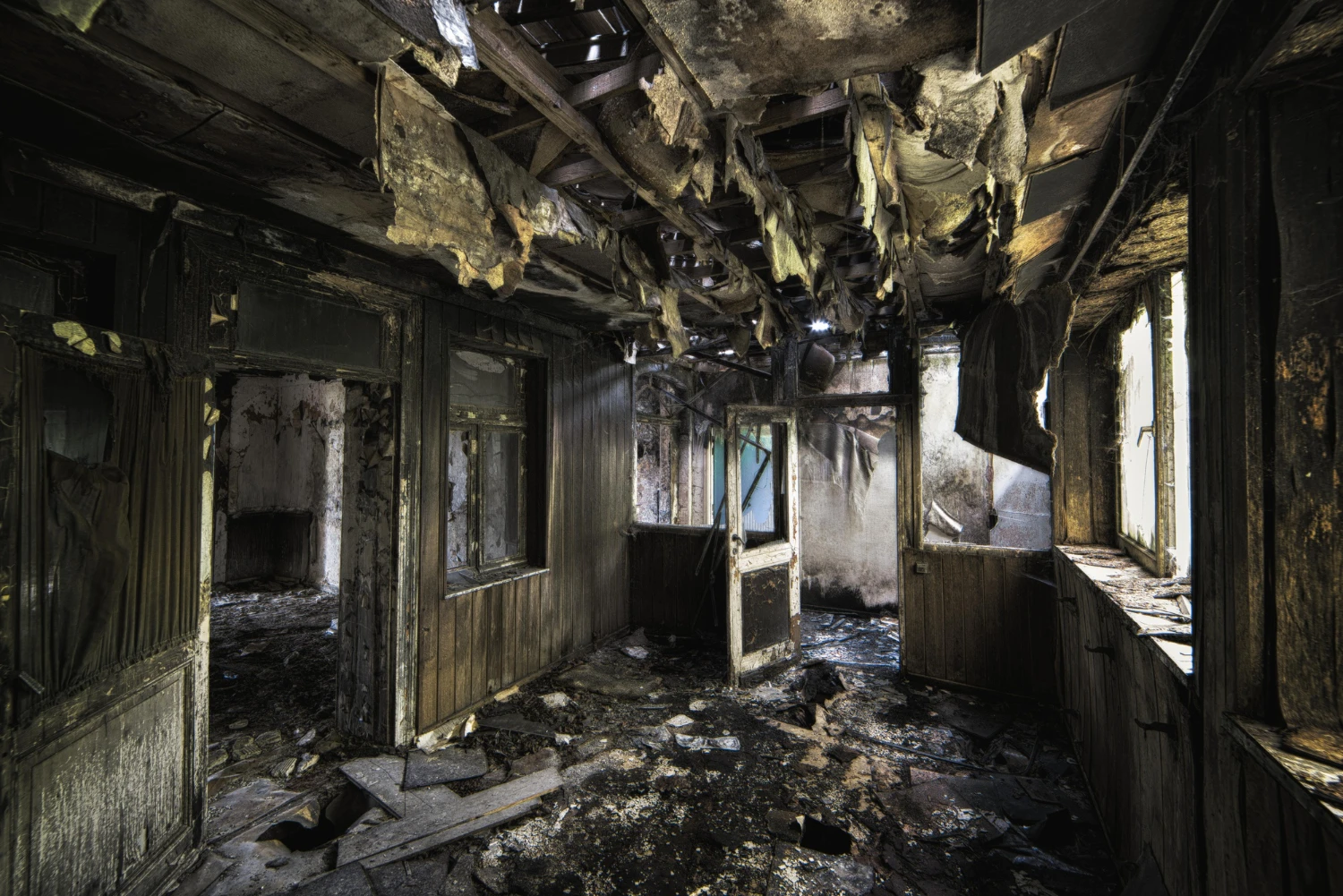 Inside shot of an abandoned destroyed building with burned walls and worn-out doors<br />