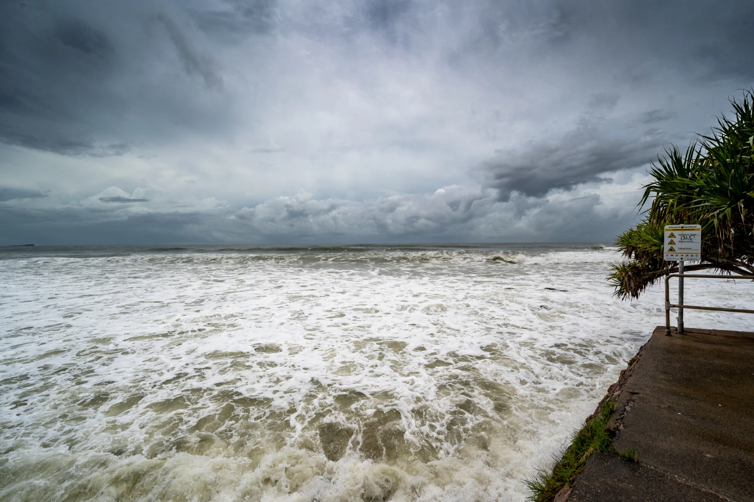 Foamy sore under dark cloudy skies in alexandra headland beach, queensland australia<br />